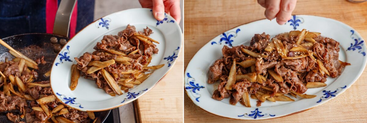 A person plates a cooked Beef and Gobo Stir Fry from a pan onto a white oval plate with blue designs, then sprinkles sesame seeds on top.