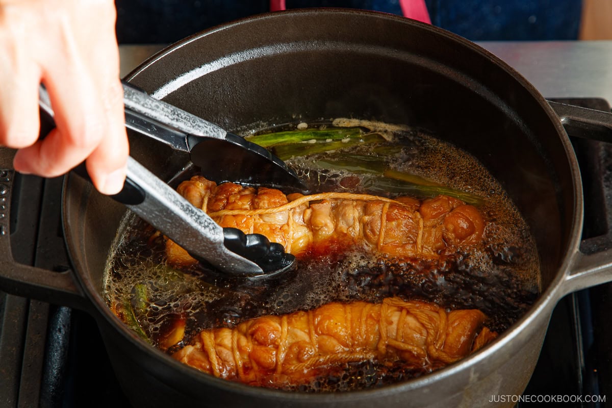 Braise the rolled chashu, the aromatics, and seasonings until cooked through.