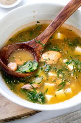 A white Japanese bowl containing cold miso soup (hiyajiru) with tofu, cucumber, and salmon).